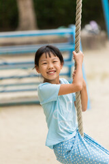 真夏の公園でターザンロープを遊んでいる可愛い子供