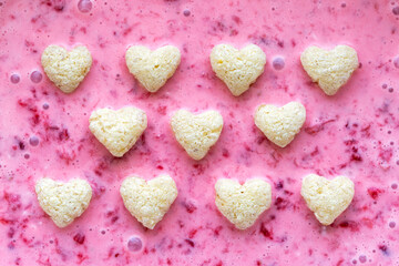 A background made up of several hearts from waffles in the background of strawberry yogurt.