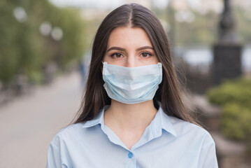 Woman portrait outdoors in a medical mask