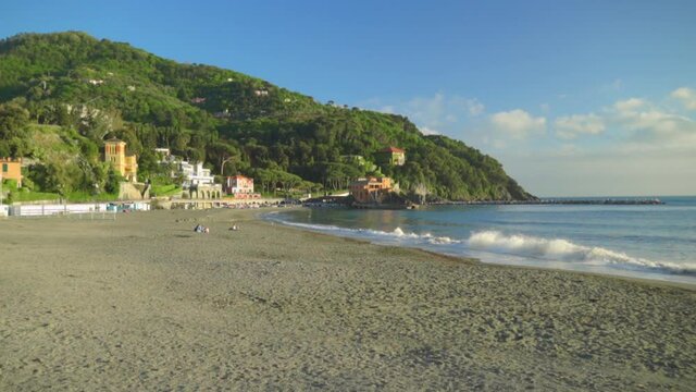 Slow motion of soft waves at empty sunny beach, Italian Riviera region