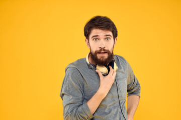 Man in headphones listens to music technology lifestyle fun people yellow background