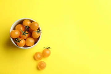 Yellow tomatoes on color background, flat lay. Space for text