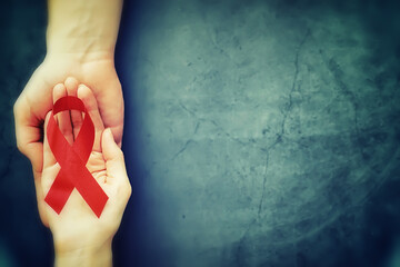 Symbol of human immunodeficiency virus disease. Red ribbon. A helping hand and support.