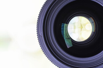 Equipment videographer and photographer. Lenses on the table against the background of bright lamps. Glare and bokeh in reflection of camera glass.