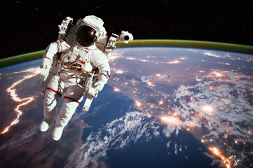 Obraz premium Astronaut walking in space with earth background. Elements of this image furnished by NASA