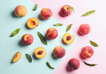Fresh ripe peaches and green leaves on color background, flat lay