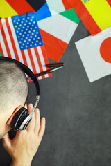 Learning foreign languages. Audio language courses. Background from countries flags and headphones on the table. © alexkich