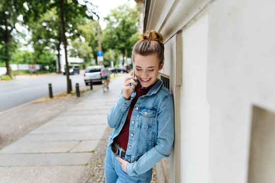 Young woman chatting on her mobile in quiet street