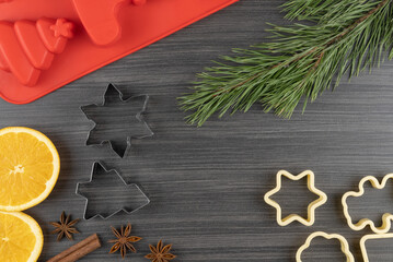 preparing festive treats for Christmas and new year holidays. cookie molds, orange and star anise. fir branches and cones. flat layout