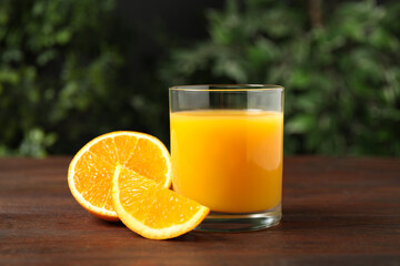 Glass of orange juice and fresh fruits on wooden table
