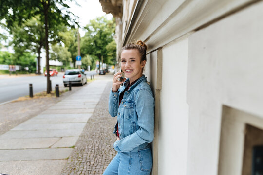 Happy casual young woman in denims in a street