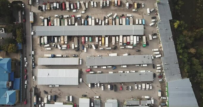 Aerial hyper lapse (hyperlapse - time lapse) of a large logistics park with a warehouse - loading hub. Semi-trucks with freight trailers standing at the ramps for loading/unloading goods