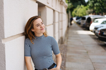 Relaxed young woman standing waiting in town