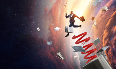 Businessman jumping on springboard . Mixed media