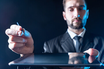 Man uses an electronic tablet. Hands of a person with an electronic tablet and a stylus close-up....