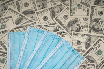  Disposable blue mask on the background of hundred dollar bills, cash dollars