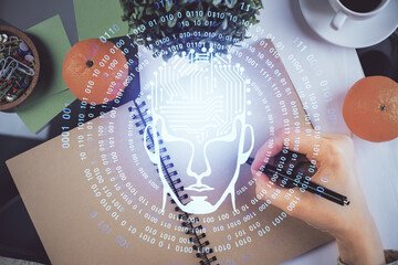 Double exposure of writing hand on background with brain hologram. Concept of learning.
