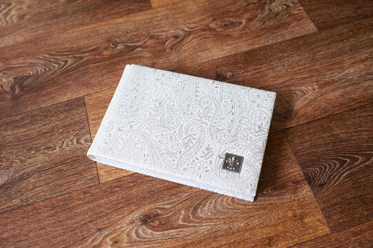 Photo book with a cover of genuine leather. White color with decorative stamping