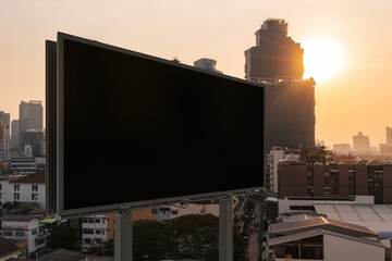 Obraz premium Blank black road billboard with Bangkok cityscape background at sunset. Street advertising poster, mock up, 3D rendering. Side view. The concept of marketing communication to promote or sell idea.
