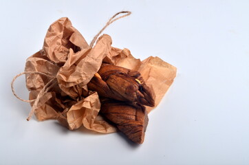 Dried melons in a paper bag, close-up, on a white background.