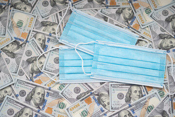  Cash one hundred dollar bills background. Disposable safety masks close up