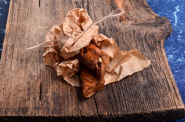 Dried melons in a paper bag, close-up, on a wooden background.