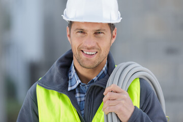 happy male builder holding cables