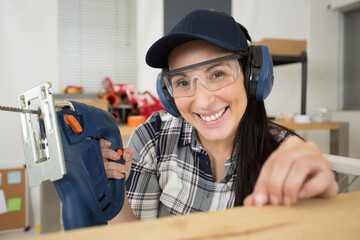 female construction worker holds an electrical saw