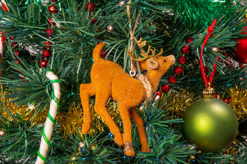Close-up on the Christmas tree, its pretty garland in the shape of a deer and its barley sugar	