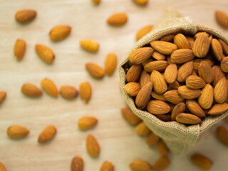 Almond in bag on blur wood table background