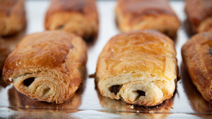 Close-up of homemade chocolate buns lined up on a silver platter	