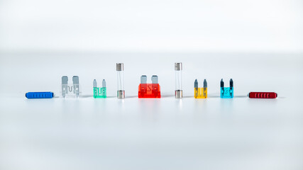 Alignment of transparent and multicolored fuses on a white background	