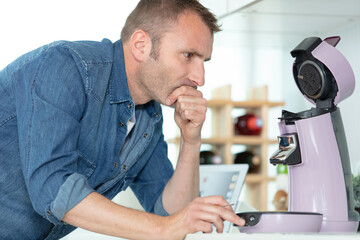 man trying to understand how to use coffee machine