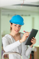 female builder with a clipboard at site