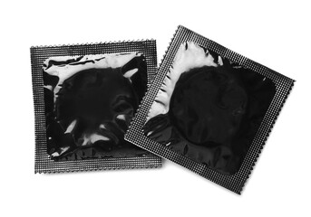 Black condom packages on white background, top view. Safe sex