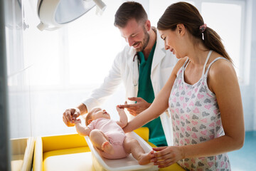 Happy beautiful mother and little baby on medical examination in pediatrician office