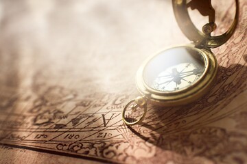 Retro styled golden antique compass (sundial) and old white nautical chart close-up. Vintage still life. Sailing accessories. Travel, navigation concepts, collecting, souvenir, gift, graphic resource © Alex Stemmer