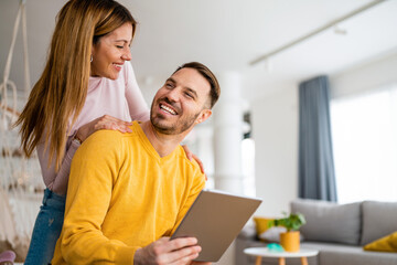 Couple in love hugging and using tablet together.