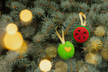 Felt toys in apple, watermelon shaped of are on a natural herringbone with yellow bokeh lights.  Creative christmas concept, hand made, hand sewn.