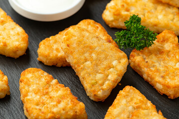 Hash brown potato patties on rustic stone board