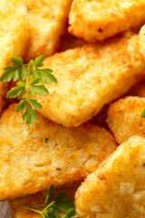 Hash brown potato with ketchup on white wooden board