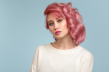 Portrait of a beautiful woman with pink hair on a blue background