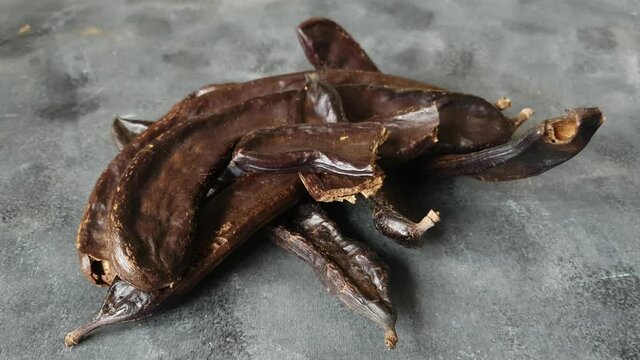 Dry carob pods and seeds close up