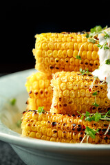 Grilled Corn on cob served with yoghurt dip, chili flakes and cress salad