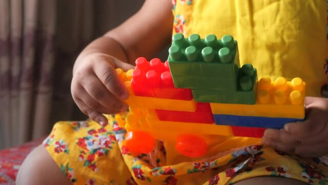 baby child playing with colorful building blocks 