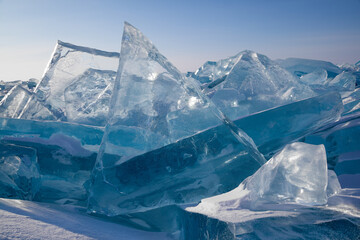 Scenic big blocks of broken transparent blue ice on clear sky background, beautiful winter landscape, closeup view