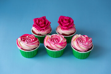 Appetizing cupcakes with pink cream on a blue background.