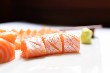 Fresh salmon and toro sashimi with shoyu and wasabi with chopsticks on mable plate. 