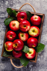 Ripe red apples in wooden box.