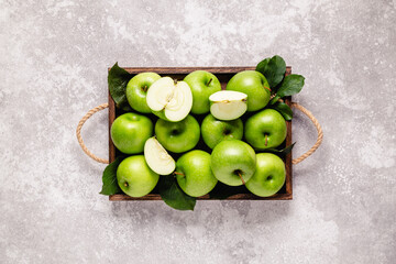 Ripe green apples in wooden box.